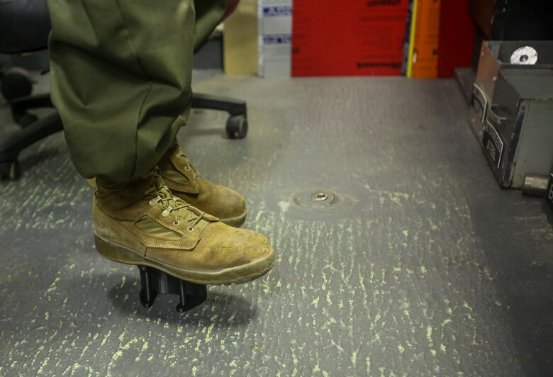 Cpl. Christopher Bigham, a machinist with CLB 26, 26th Marine Expeditionary Unit (MEU), stands on a bracket that he created with a 3D printer to demonstrate the strength and durability of 3D printed parts aboard the amphibious assault ship USS Iwo Jima (LHD 7) in the Atlantic Ocean, Feb. 21, 2018