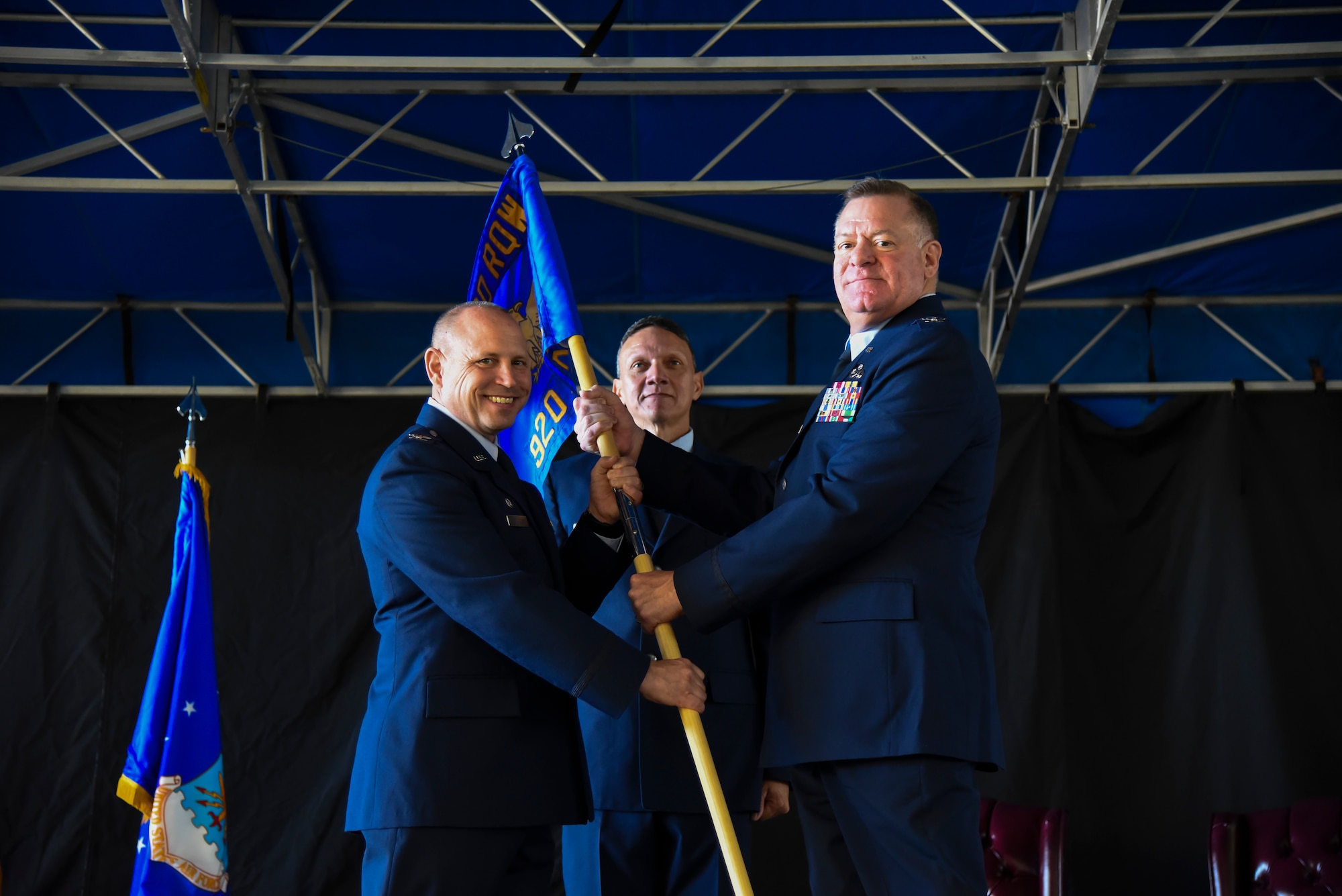 Col. Kurt Matthews (left), 920th Rescue Wing Commander, hands Col. Leo J. Kamphaus, Jr. (right) the 920th Maintenance Group guidon, officially recognizing Kamphaus’ assumption of command over the maintenance group. The ceremony is a common staple in military units around the world. (U.S. Air Force photo by Senior Airman Brandon Kalloo Sanes)