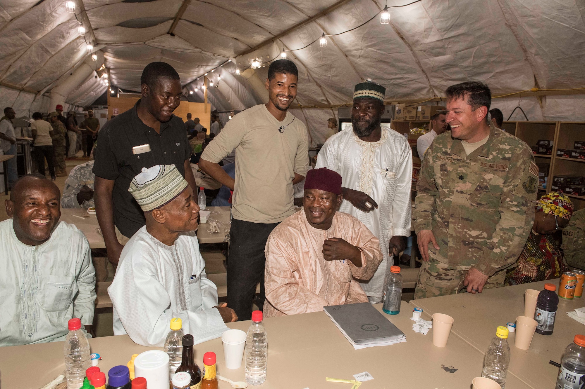U.S. Air Force Lt. Col. Brad Harbaugh, 724th Expeditionary Air Base Squadron commander, laughs with members of the Forces Armées Nigeriennes and Agadez civic leaders during a social gathering at Nigerien Air Base 201’s dining facility, Feb. 21, 2018. The U.S. military is in Agadez at the request of the Government of Niger, and remains committed to helping its African partners protect their borders with matters of national security, and with other efforts important to the citizens of Niger. (U.S. Air Force photo by Tech. Sgt. Nick Wilson)