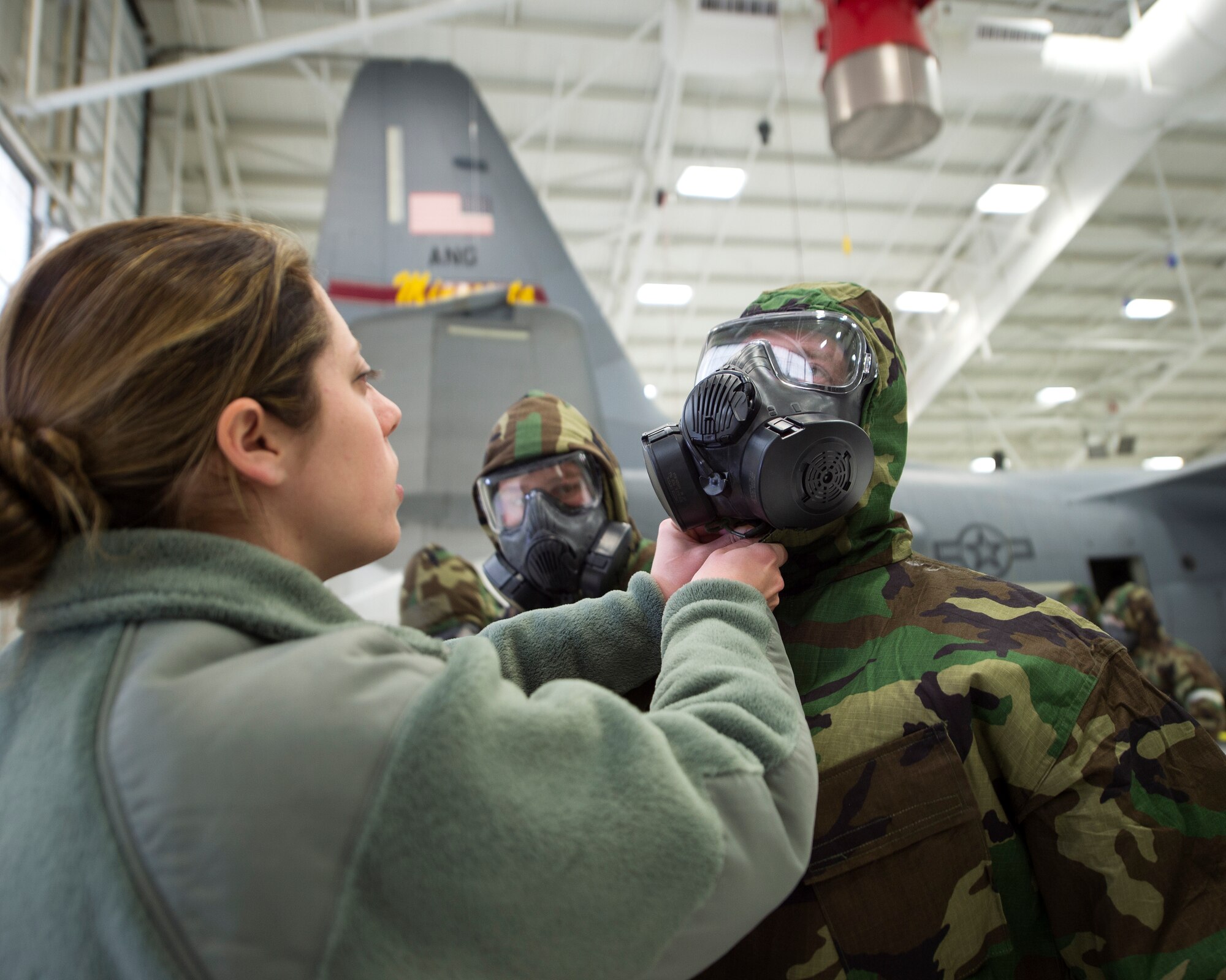 U.S. Air Force Tech. Sgt. Sara Passint, left, with the 133rd Civil Engineer Squadron, helps another Airman to secure their hood in St. Paul, Minn., Feb. 24, 2018.