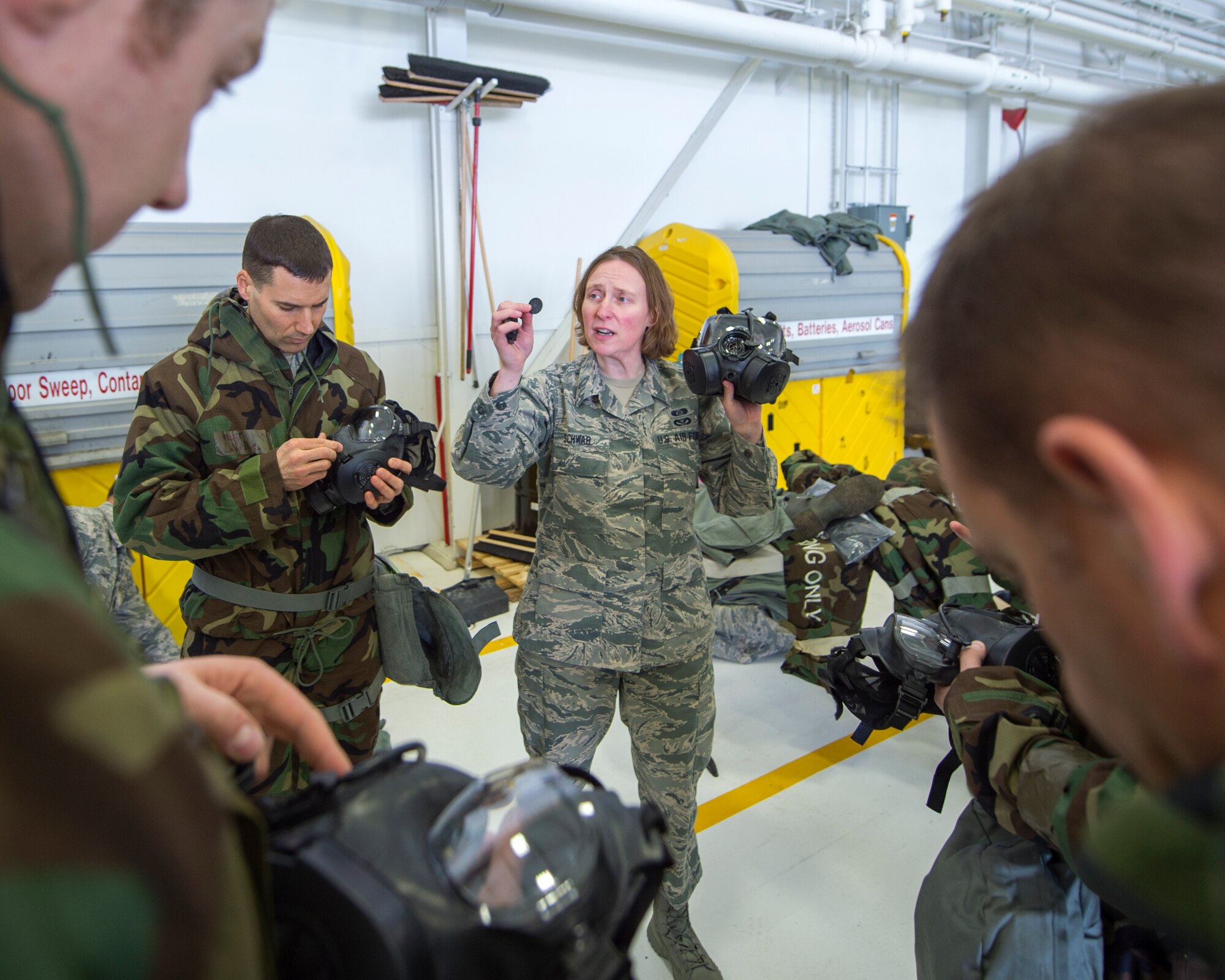 U.S. Air Force Staff Sgt. Tes Schwab, center, with the 133rd Civil Engineer Squadron, talks about the different parts to the M50 Joint Service General Purpose Mask in St. Paul, Minn., Feb. 24, 2018.