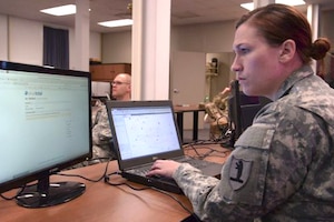 A soldier works at her computer.