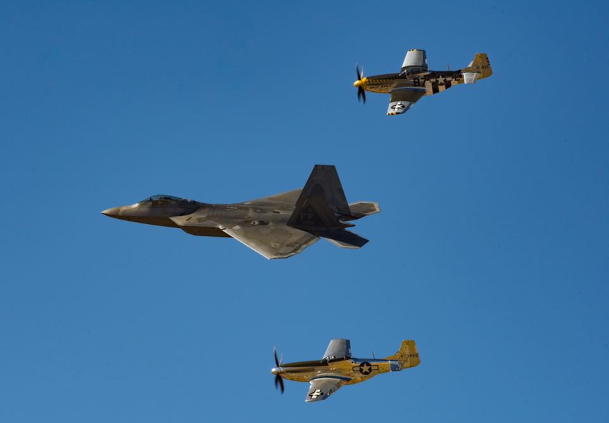 Photo of a F-22 Raptor in formation with two P-51 Mustangs at Heritage Flight Training