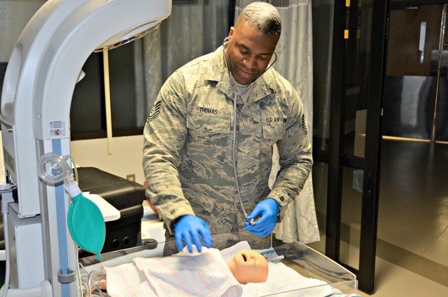 Tech. Sgt. Jason Thomas demonstrates checking vital signs on a newborn baby manikin.