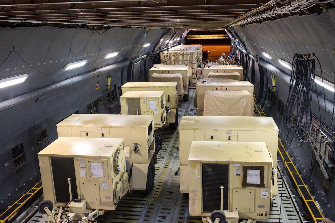 Airmen load generators and cargo onto a C-5M Super Galaxy aircraft.
