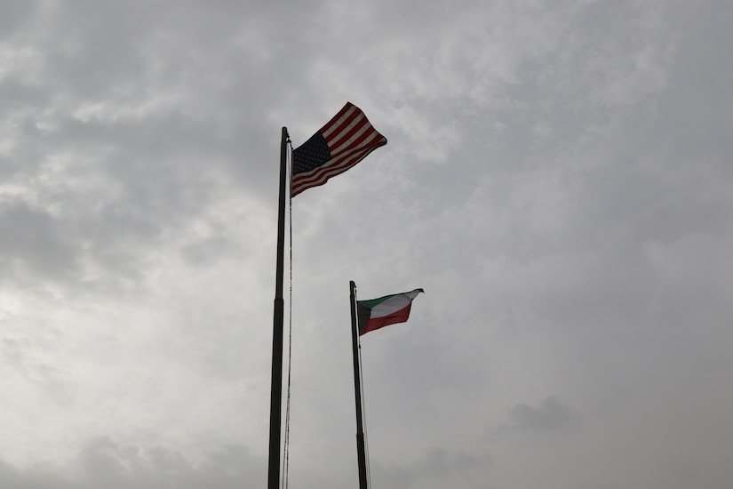 A new Kuwaiti flag flies by the American flag during a ceremony on Camp Patriot, Kuwait