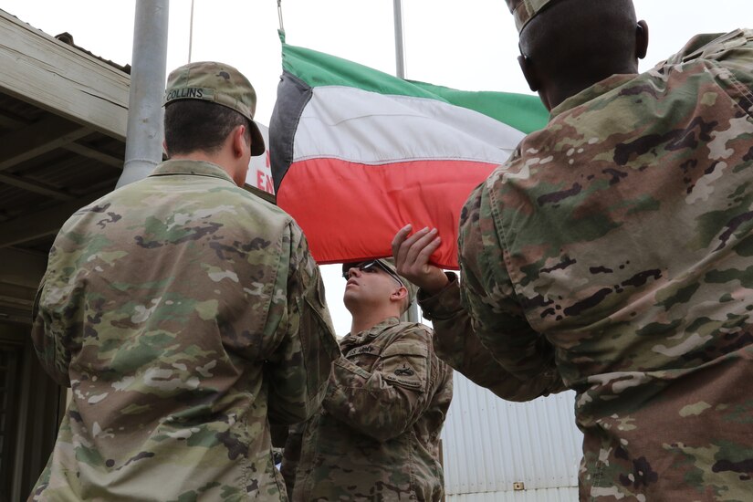 A flag detail from the 40th Brigade Engineer Battalion lowers an aging Kuwaiti Flag