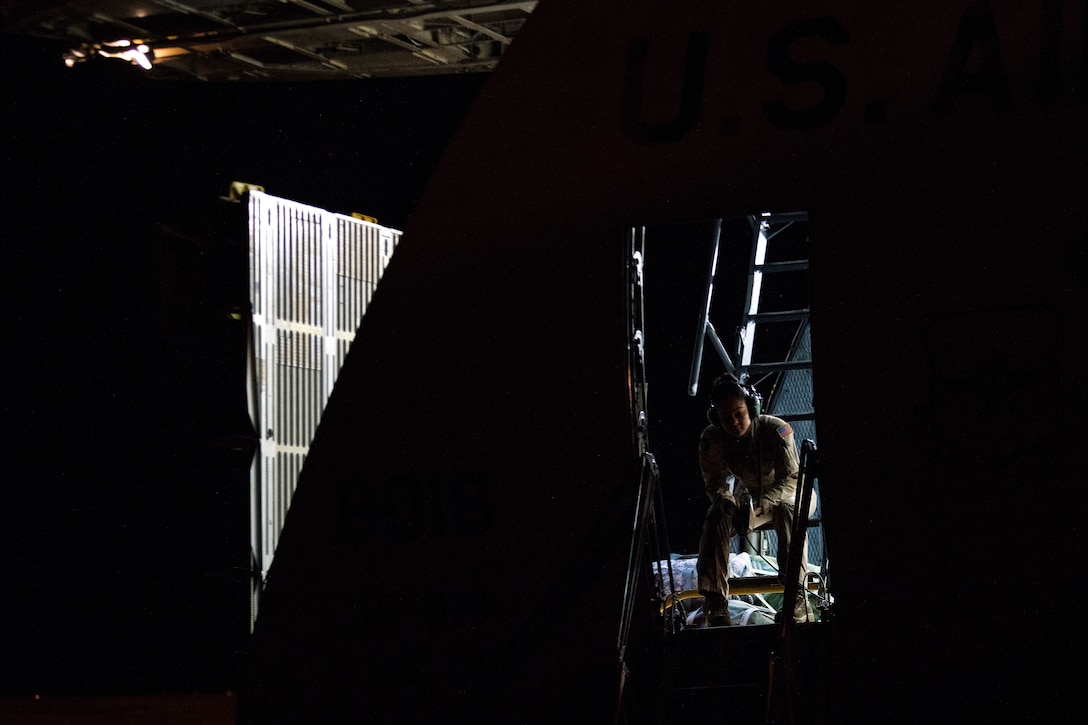 Senior Airman Lauren Foote waits for cargo to be loaded onto a C-5M Super Galaxy aircraft.