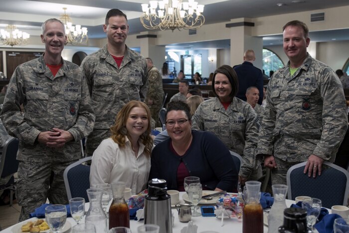 Service members pose for a photo with their spouses.