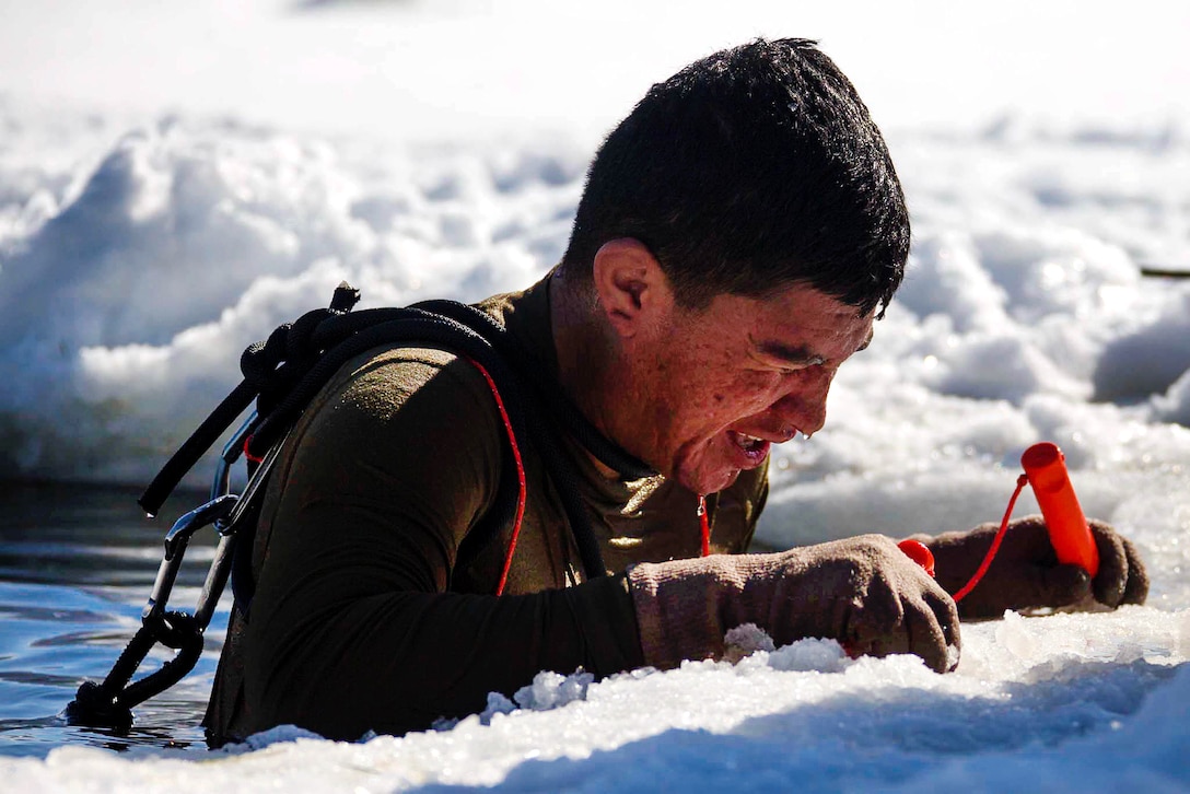 Lance Cpl. George Pena stands in freezing water while talking to an instructor as part of cold-water immersion training.