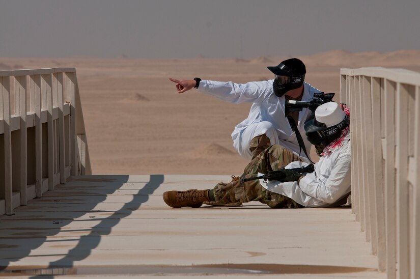 Opposing forces role players from 1st Battalion, 145th Field Artillery Regiment, Utah National Guard, coordinate an attack against other members of their unit during training on Gerber Training Area, Udairi Range Complex, Kuwait, Feb. 26, 2018. The exercise included an IED lane and enemy fire in a hostile village before culminating in a simulated medical evacuation with a UH-60 Black Hawk air ambulance.