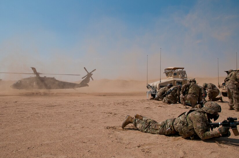 Soldiers from Delta Battery, 1st Battalion, 145th Field Artillery Regiment, Utah National Guard, prepare to carry simulated casualties to a UH-60 Black Hawk air ambulance during training on Gerber Training Area, Udairi Range Complex, Kuwait, Feb. 26, 2018. The exercise included an IED lane and enemy fire in a hostile village before culminating in the simulated medical evacuation.