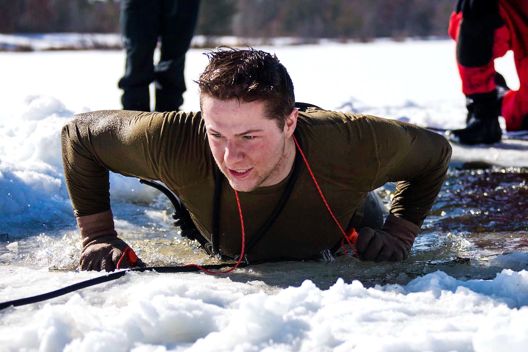 Cpl. John Batchelor pulls himself out of freezing water as part of cold water immersion training.