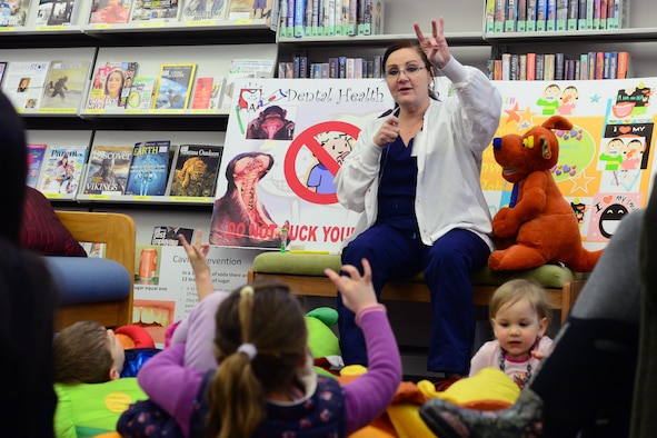 Mercy Padgett, 341st Medical Operations Squadron chief of preventative dentistry, shows children how to properly use floss Feb. 20, 2018, at Malmstrom Air Force Base, Mont.