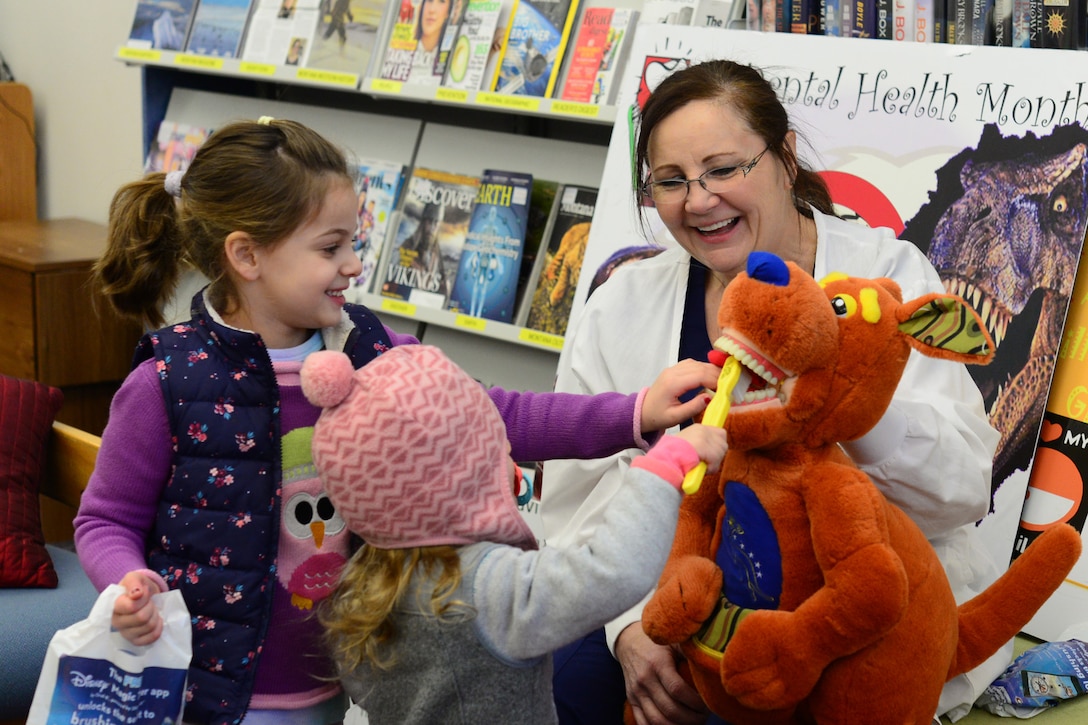 Mercy Padgett, 341st Medical Operations Squadron chief of preventative dentistry, uses a mascot, Roo, to teach children how to properly brush their teeth Feb. 20, 2018, at Malmstrom Air Force Base, Mont.
