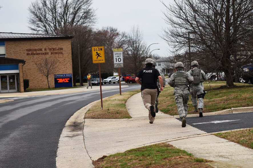 Members of the 436th Security Forces Squadron run toward the George S. Welch Elementary School and Dover Air Force Base Middle School during an active shooter exercise Feb. 26, 2018, on Dover AFB, Del. The teachers were given small-group classroom specific training in addition to the exercise to sharpen their skills. (U.S. Air Force photo by Airman 1st Class Zoe M. Wockenfuss)
