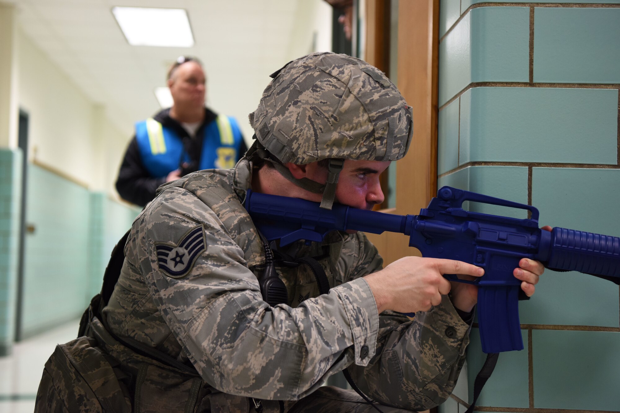 Staff Sgt. Issac McCauley, 436th Security Forces Squadron, stands guard in the George S. Welch Elementary School during an active shooter exercise Feb. 26, 2018, at Dover Air Force Base, Del. All responding defenders exchanged their duty weapons and ammunition for blue training replicas at the beginning of the exercise. (U.S. Air Force photo by Airman 1st Class Zoe M. Wockenfuss)