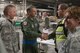 Fourth Air Force commander Maj. Gen. Randall A. Ogden (second from left) presents Senior Master Sgt. Bradley Levander with a challenge coin March 3, 2018, in the cargo warehouse on Joint Base Charleston, S.C. Ogden recently visited the 315th Airlift Wing where he met with Airmen to talk progress and innovation. (U.S. Air Force illustration by 1st Lt. Rashard Coaxum)