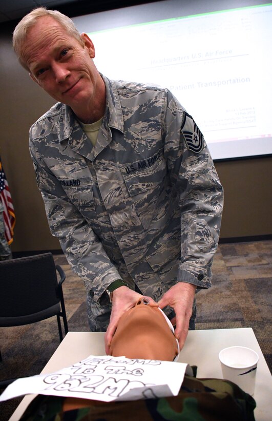 Master Sgt. Blair Bookland, 932nd Medical Group, holds a simulated accident victim's head during a medical training scenario Feb. 11, 2018.  Bookland and his fellow 932nd Medical Squadron members taught self aid and buddy classes for unit Airmen. Bookland and other 932nd MDS reservists conducted the transportation and first aid skills demonstration which highlights the specialized training Air Force Reserve medical personnel receive. The 932nd Airlift Wing is located on Scott Air Force Base, Ill., and trains one weekend a month during Unit Training Assemlbly.  The 932nd AW is the only Air Force Reserve unit that flies the C-40C.  (U.S. Air Force photo by Lt. Col. Stan Paregien)