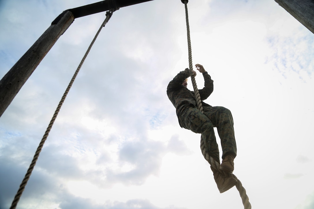 A U.S. Marine climbs the rope at the end of the obstacle course on Marine Corps Base Hawaii, March 2, 2018. In celebration of Marine Aircraft Group 24’s birthday, 13 Marines from each of its subordinate units participated in the competition to develop combat readiness, competitive spirit and camaraderie. The Marines ran the course for points based on time.