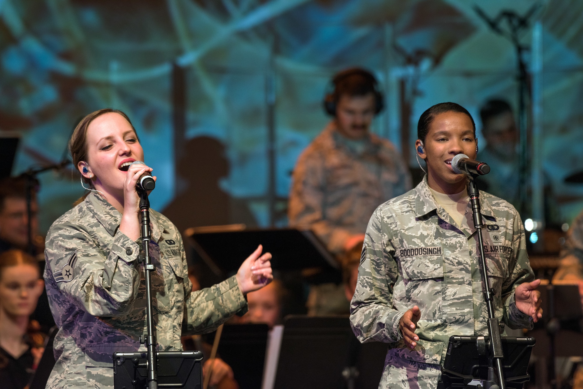U.S. Air Force Airman 1st Class Kayla Highsmith, left, and Senior Airman Salina Boodoosingh, both vocalists with the rock music group “Mobility” of The United States Air Force Band of the Golden West, Travis Air Force Base, Calif., perform with musicians from the Napa Valley Youth Symphony at the Veteran’s Home in Yountville, Calif., March 4, 2018. The band and symphony are performing together after the original concert, scheduled in October 2017, was canceled due to devastating wildfires in Napa and Sonoma counties. (U.S. Air Force photo by Louis Briscese)