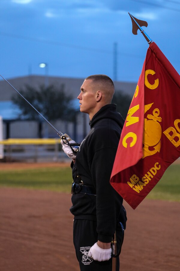 Captain Matthew S. Galadyk, platoon commander, U.S. Marine Corps Silent Drill Platoon, renders honors during the playing of the National Anthem at the annual Battle Color Detachment training evolution at Marine Corps Air Station Yuma, Az., Feb. 21, 2018. The BCD consists of the Silent Drill Platoon, “The Commandant’s Own,” the United States Marine Drum & Bugle Corps and the Marine Corps Color Guard. The BCD conducts this training in order to refine and reform drill movements and performances for this upcoming West Coast Tour and 2018 parade season. (Official Marine Corps photo by Cpl. Damon A. Mclean/Released)