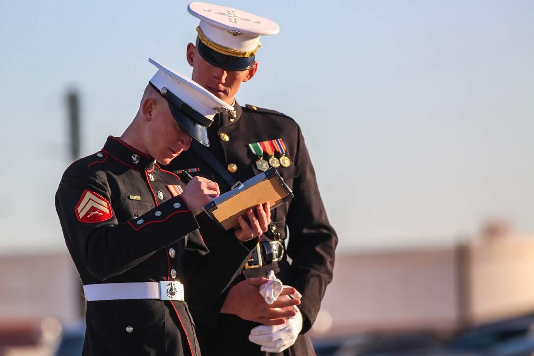 Captain Matthew S. Galadyk, platoon commander, U.S. Marine Corps Silent Drill Platoon reviews score sheets with Cpl. Ryan Watkins, rifle inspector, during the platoon’s “Challenge Day” while participating in the annual Battle Color Detachment training evolution at Marine Corps Air Station Yuma, Az., Feb. 26, 2018. Each Marine performed the scripted throws, spins and drill movements as the drill master and rifle inspectors evaluated them to choose the rifle inspection team for 2018 parade season. The Marines were chosen based on several factors; including bearing, uniforms, and proficiency.(Official Marine Corps photo by Cpl. Damon A. Mclean/Released)