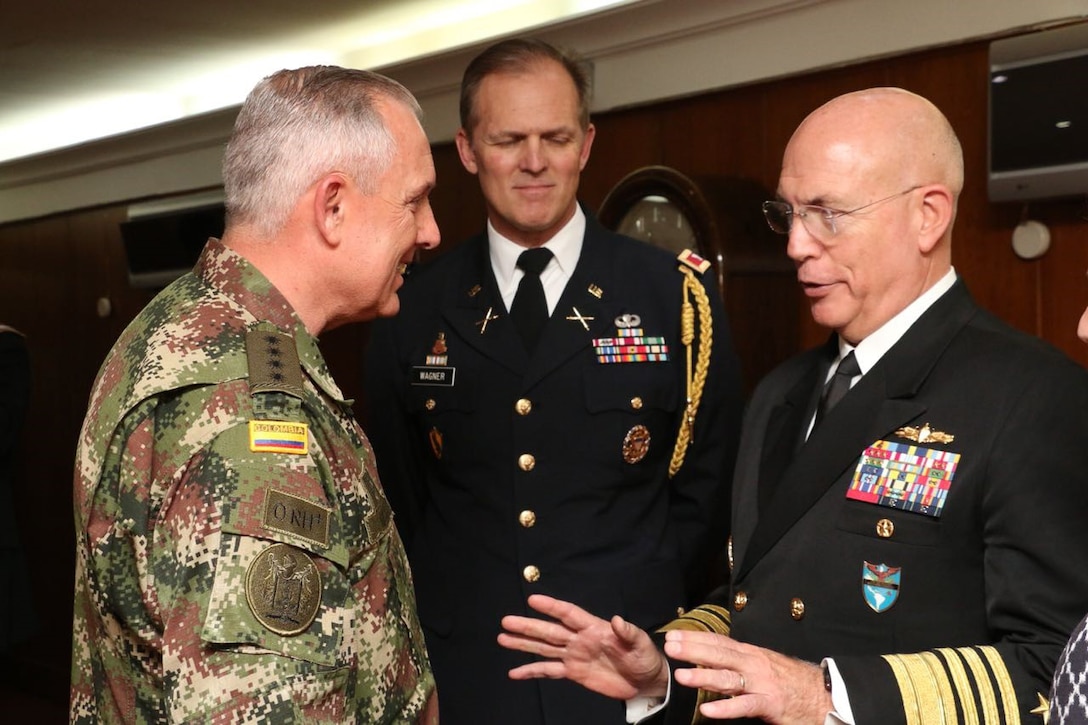 Three military leaders have a discussion.