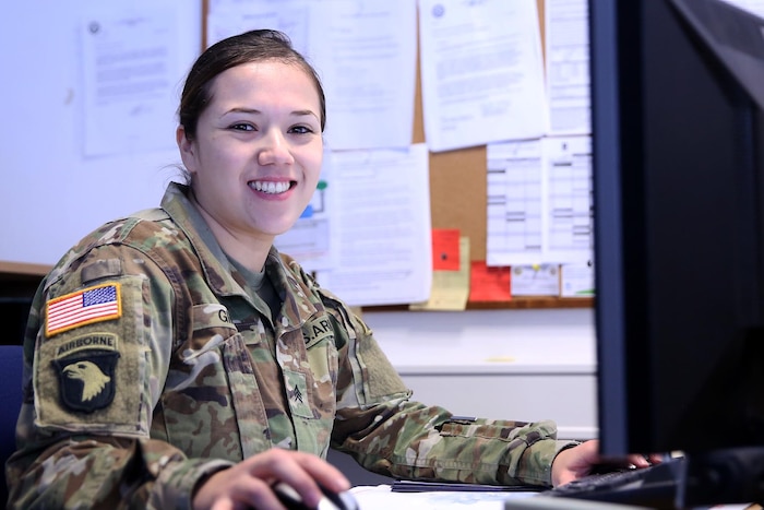 Headshot of a female soldier sitting at a desk.
