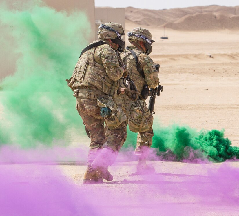 Artillerymen of Delta Battery, 1st Battalion, 145th Field Artillery Regiment, charge towards a village after deploying smoke grenades during a training exercise at a base near Camp Buehring, Kuwait, Feb. 28, 2018.