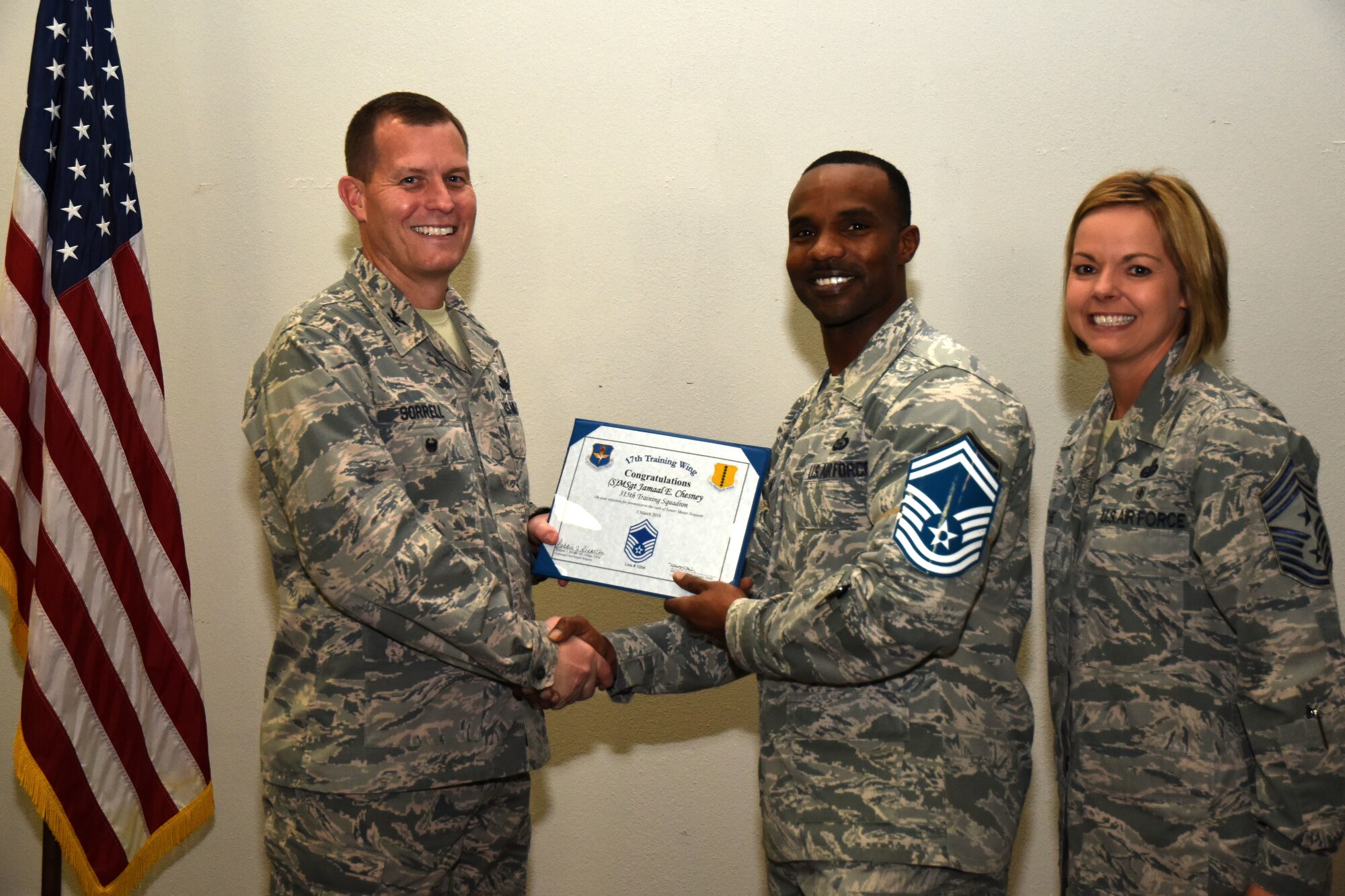 U.S. Air Force Col. Jeffrey Sorrell, 17th Training Wing vice commander, presents Master Sgt. Jamaal Chesney, 315th Training Squadron assistant first sergeant, a promotion certificate with Chief Master Sgt. Bobbie Reinsche, 17th Training Wing command chief, at the Event Center on Goodfellow Air Force Base, Texas, March 1, 2018. In celebration of individuals being selected for senior master sergeant, a party was held at the Event Center. (U.S. Air Force photo by Airman 1st Class Seraiah Hines/Released)