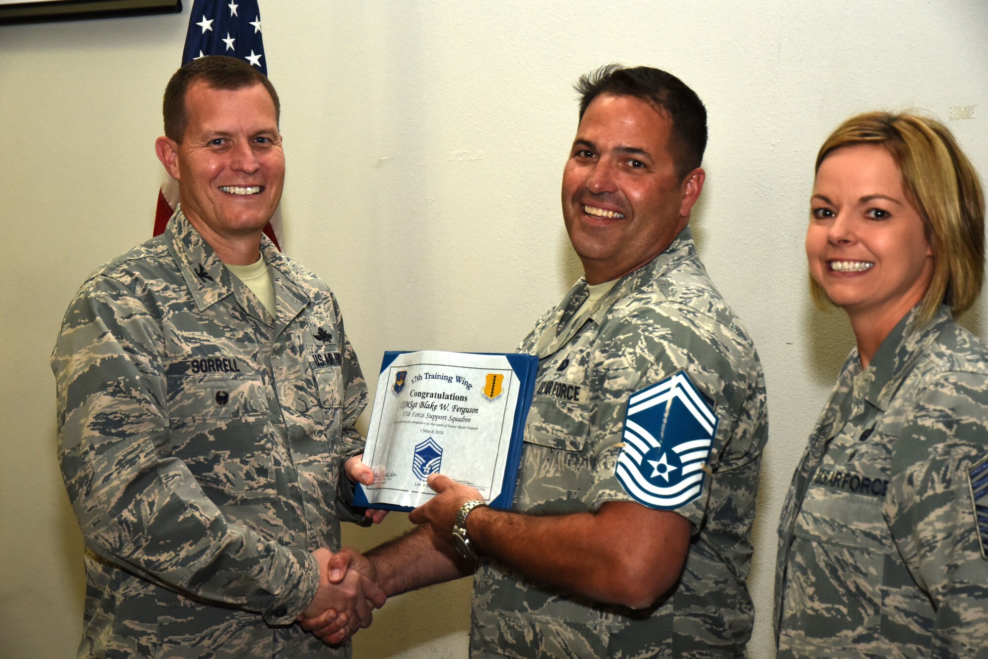 U.S. Air Force Col. Jeffrey Sorrell, 17th Training Wing vice commander, presents Master Sgt. Blake Ferguson, 17th Force Support Squadron Airman Leadership School commandant, a promotion certificate with Chief Master Sgt. Bobbie Reinsche, 17th Training Wing command chief, at the Event Center on Goodfellow Air Force Base, Texas, March 1, 2018. In celebration of individuals being selected for senior master sergeant, a party was held at the Event Center. (U.S. Air Force photo by Airman 1st Class Seraiah Hines/Released)