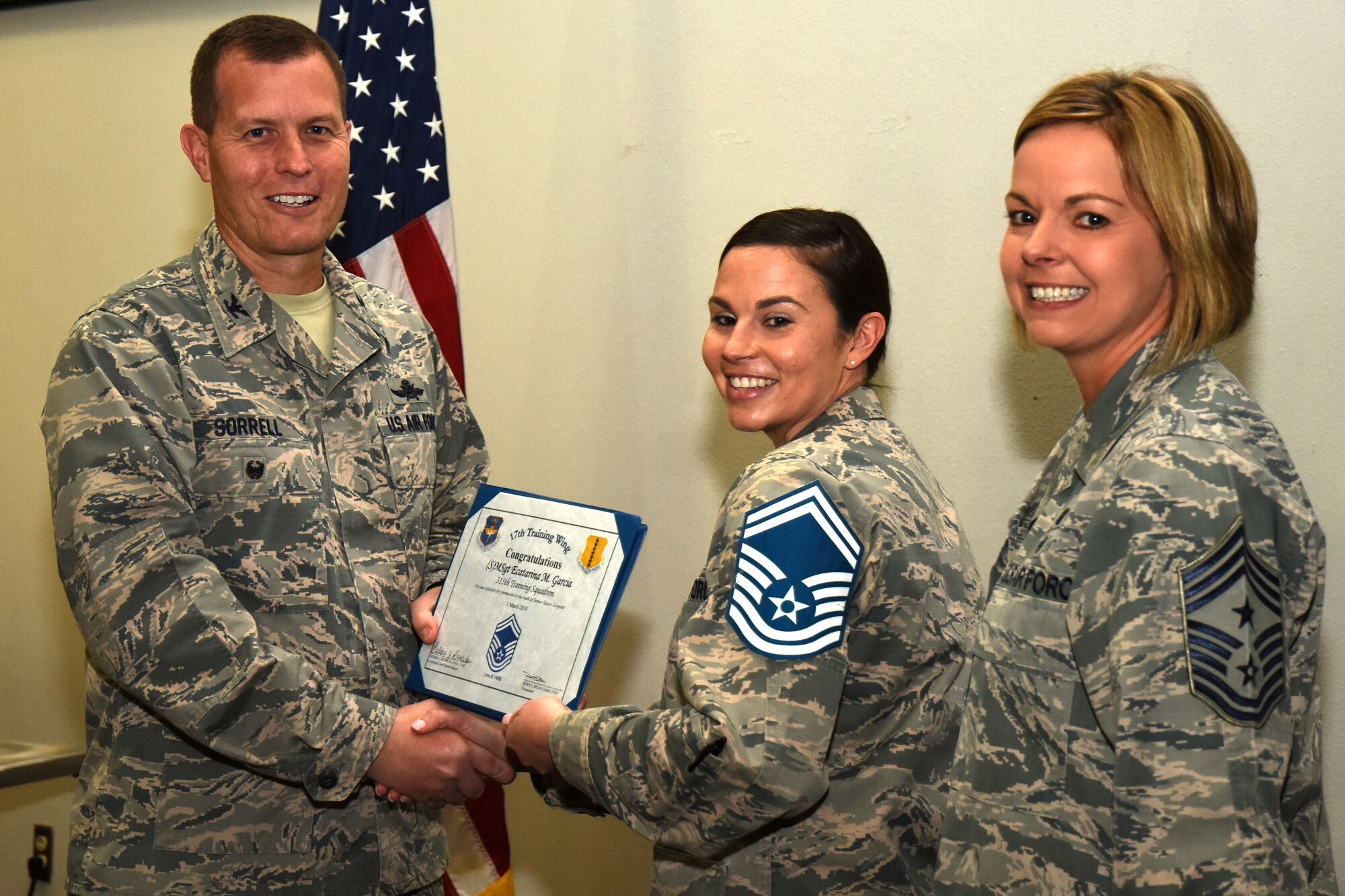 U.S. Air Force Col. Jeffrey Sorrell, 17th Training Wing vice commander, presents Master Sgt. Ecatarina Garcia, 315th Training Squadron instructor, a promotion certificate with Chief Master Sgt. Bobbie Reinsche, 17th Training Wing command chief, at the Event Center on Goodfellow Air Force Base, Texas, March 1, 2018. In celebration of individuals being selected for senior master sergeant, a party was held at the Event Center. (U.S. Air Force photo by Airman 1st Class Seraiah Hines/Released)