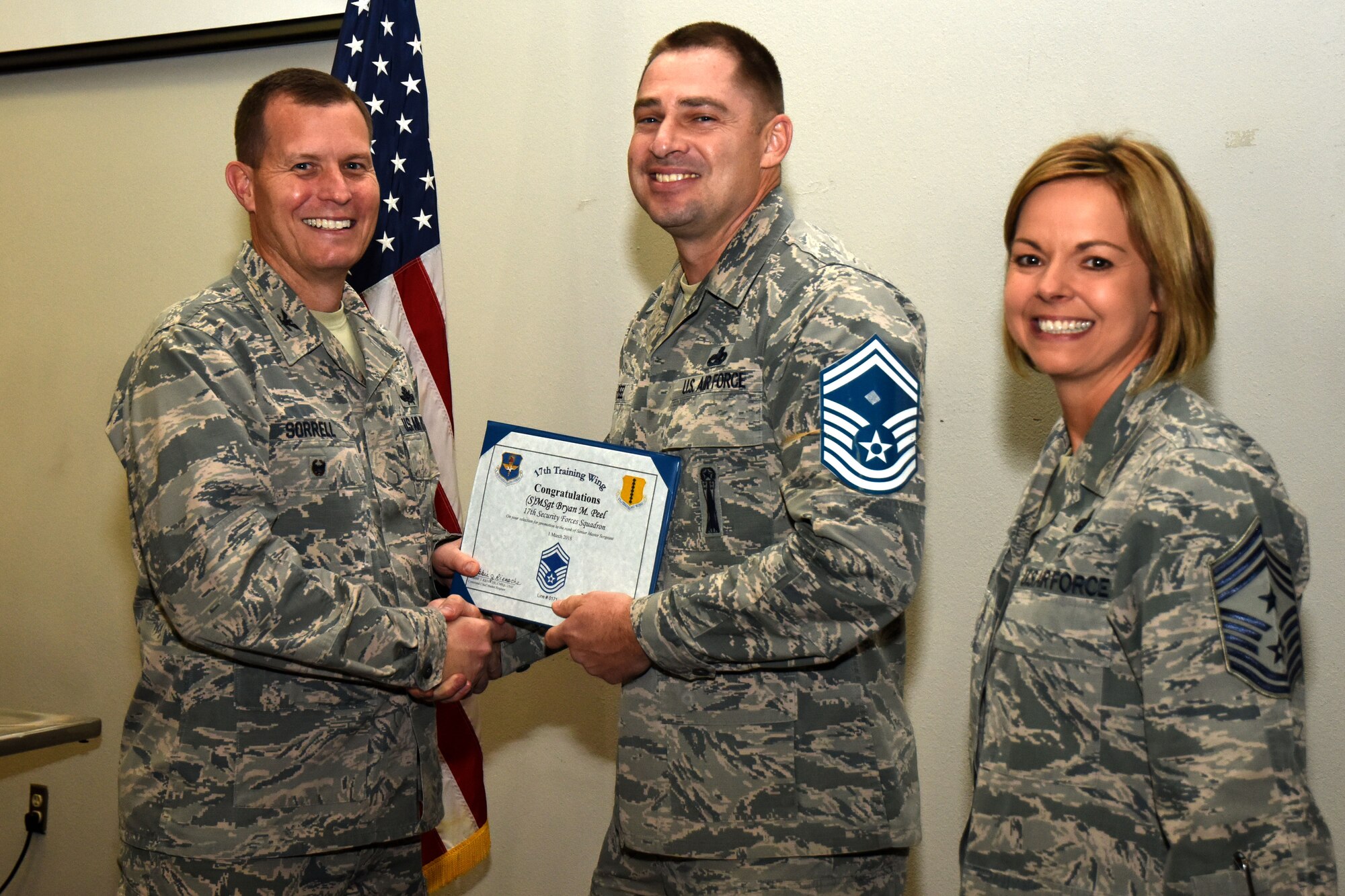 U.S. Air Force Col. Jeffrey Sorrell, 17th Training Wing vice commander, presents Master Sgt. Bryan Peel, 17th Security Forces Squadron first sergeant, a promotion certificate with Chief Master Sgt. Bobbie Reinsche, 17th Training Wing command chief, at the Event Center on Goodfellow Air Force Base, Texas, March 1, 2018. In celebration of individuals being selected for senior master sergeant, a party was held at the Event Center. (U.S. Air Force photo by Airman 1st Class Seraiah Hines/Released)