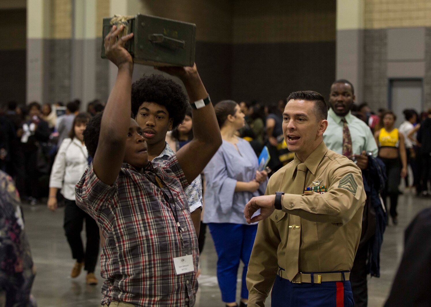 Gunnery Sergeant Bryan Davis, staff noncommissioned officer-in-charge of Recruiting Substation Charlotte, observes an attendant of the Central Intercollegiate Athletic Association (CIAA) Education Day participating in ammo-can lifts at the Charlotte Convention Center, Charlotte, North Carolina, on Feb. 28, 2018. The Marines took part in the Education Day at the CIAA to spread awareness and inform others of the opportunities the Marine Corps can provide. The Education Day assists recruiters by offering them different tools to reach students across the state. (U.S. Marine Corps photo by Lance Cpl. Jack A. E. Rigsby)