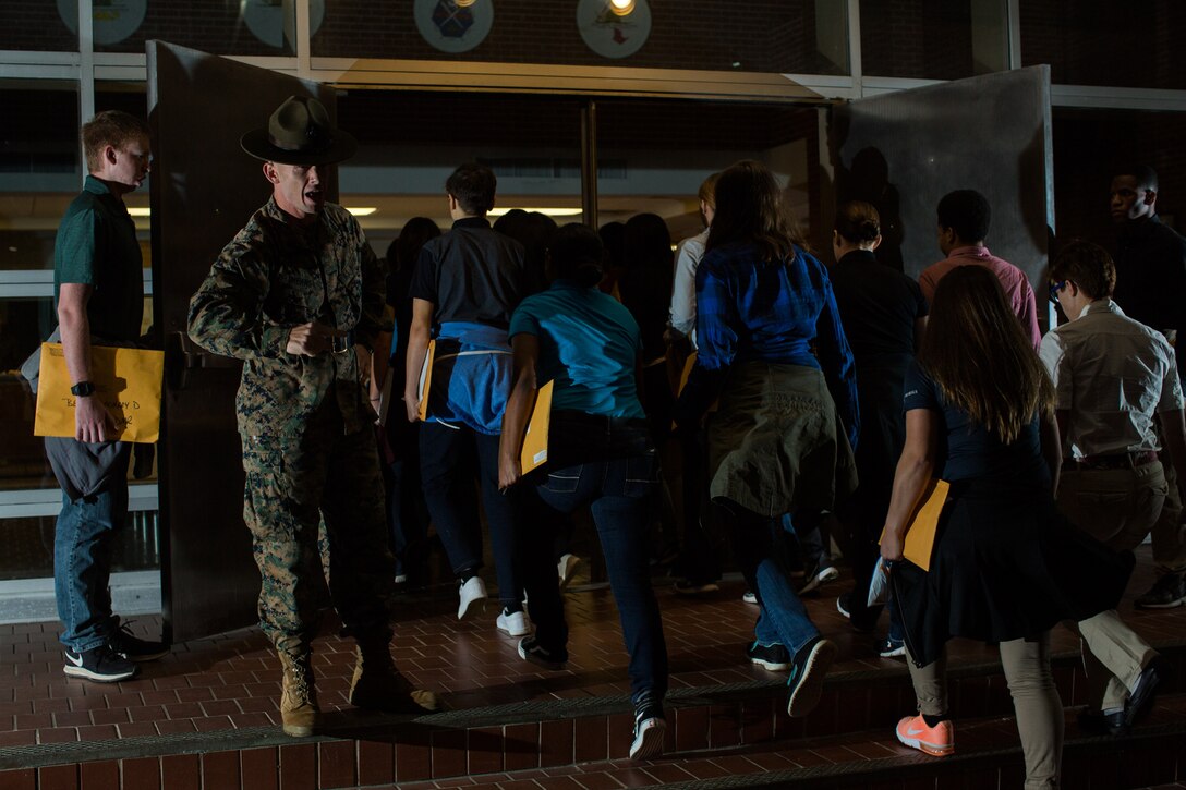 Senior drill instructor Staff Sgt. Michael Means Jr. gives the young men and women who just stepped onto the yellow footprints their first orders on Parris Island. These young men and women are scheduled to join Delta and Oscar Companies to begin their training in the next few days. (Photo by Lance Cpl. Carlin Warren)