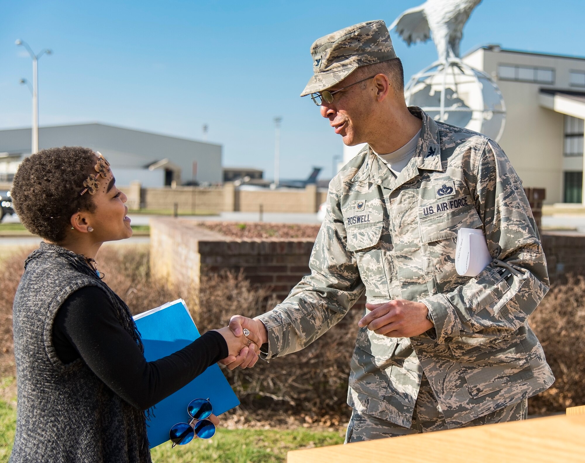Col. Randy Boswell, 436th Mission Support Group commander, presents a coin to Ikira Peace, guest speaker for the Black History Month Unity Walk, Feb. 28, 2018, on Dover Air Force Base, Del. Peace, a native of Baltimore, Md., is a senior at the University of Delaware, Newark, Del. (U.S. Air Force photo by Roland Balik)