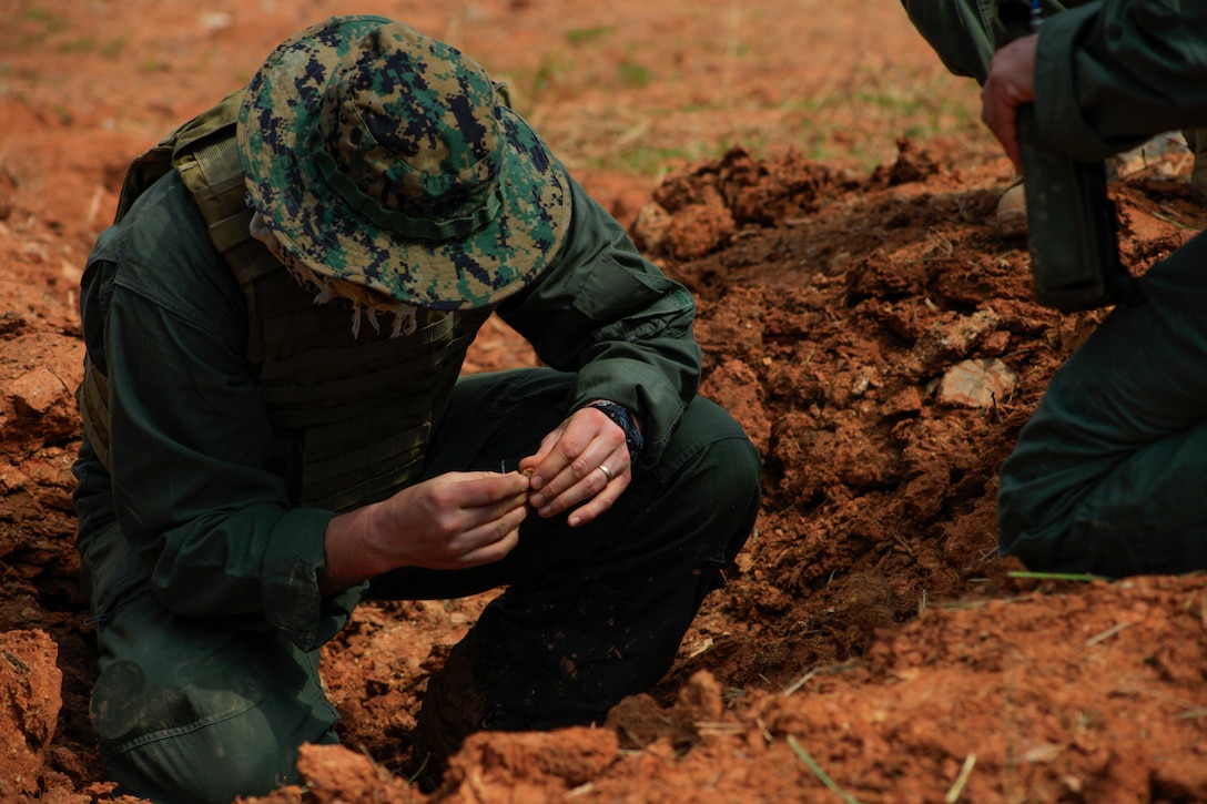 An explosive ordnance disposal technician with Combat Logistics Battalion 31 performs a post blast analysis during EOD exploitation training at Camp Schwab, Okinawa, Japan, March 1, 2018.