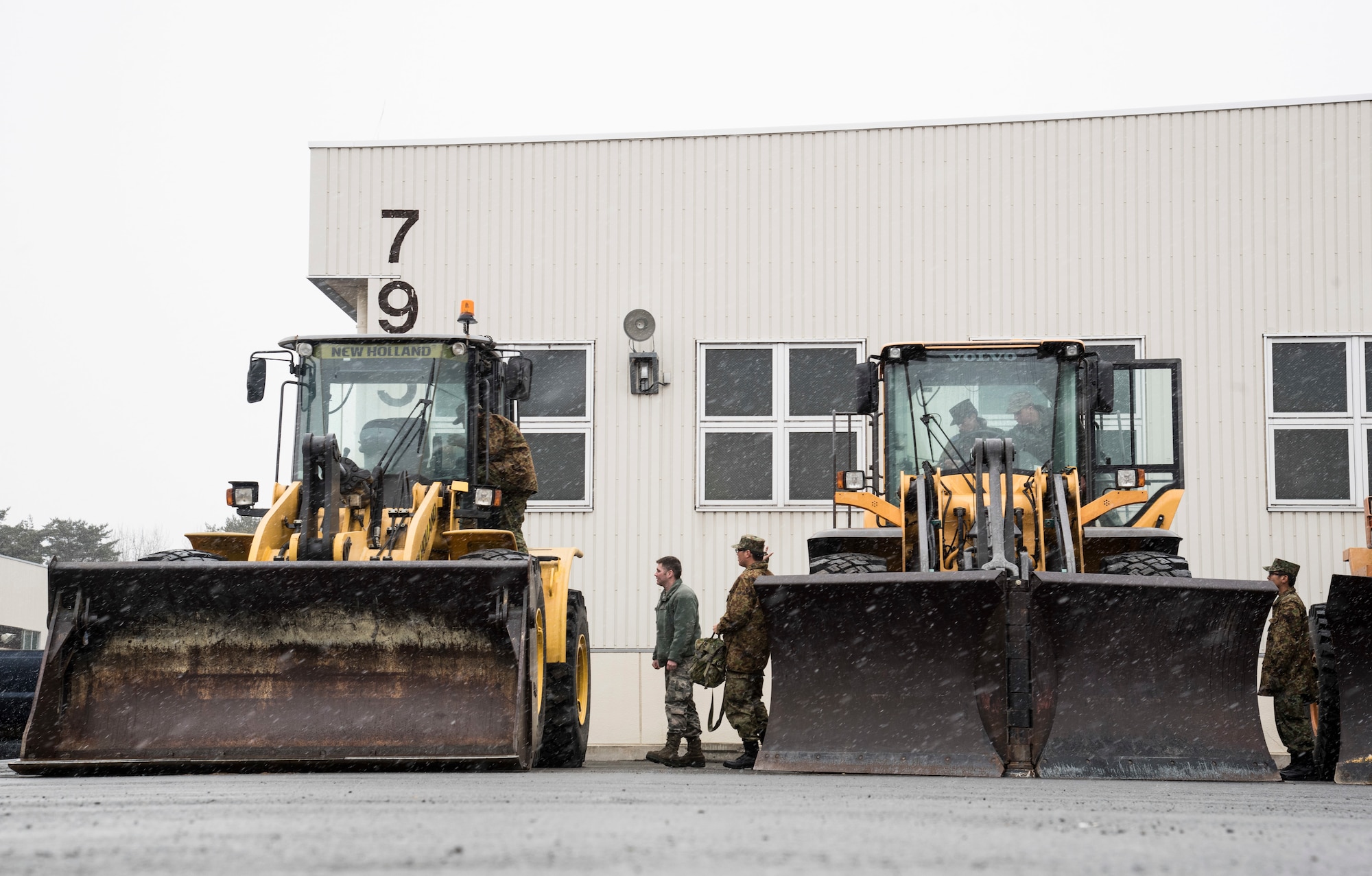 Japan Ground Self-Defense Force Soldiers from the 1st Training Unit at Camp Higashi-Chitose, Hokkaido, Japan, tour a front end loader and a v-plow with U.S. Air Force Airmen with the 35th Civil Engineer Squadron at Misawa Air Base, Japan, March 5, 2018,. Misawa AB works with JGSDF Soldiers to complete their basic English course final evaluation by attending a career field exchange with their U.S. Air Force counterparts practicing military English terms. The course, held at Camp Higashi-Chitose, Hokkaido, Japan, enhances future bilateral missions and enables seamless execution by breaking down social barriers. (U.S. Air Force photo by Senior Airman Sadie Colbert)