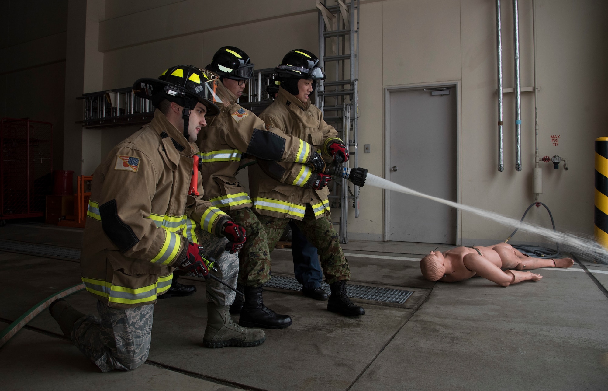 U.S. Air Force Senior Airman Daniel Brunn, left, a 35th Civil Engineer Squadron firefighter, shows Japan Ground Self-Defense Force Sergeants Kensuke Fujita, center, and Kenta Takahashi, right, how to properly handle a firehose during a JGSDF shadow program at Misawa Air Base, Japan, March 5, 2018. The program showcased Team Misawa’s ability to work together with any branch of the Japan Self-Defense Force. U.S. Air Force Airmen and JGSDF Soldiers worked on their communications skills cultivating a face-to-face friendly environment for future bilateral events with the Soldiers. (U.S. Air Force photo by Senior Airman Sadie Colbert)