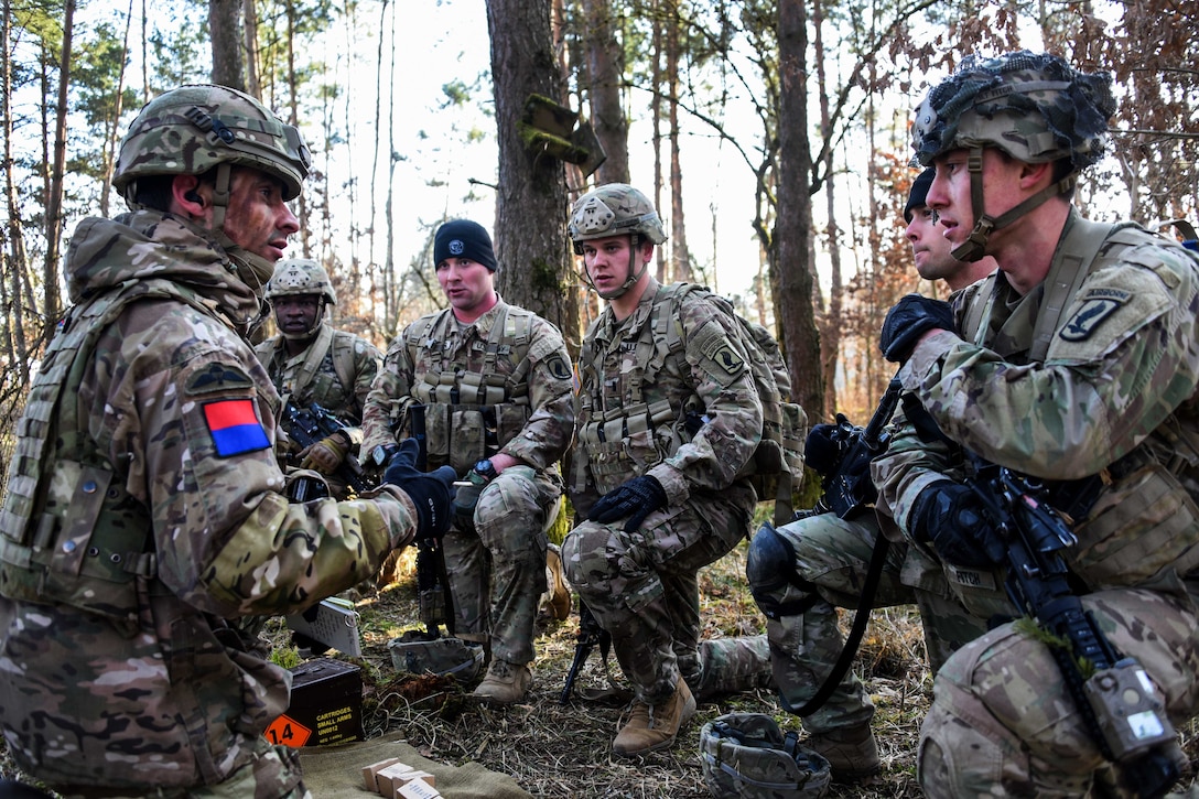 A British soldier conducts a range safety briefing with U.S. soldiers.