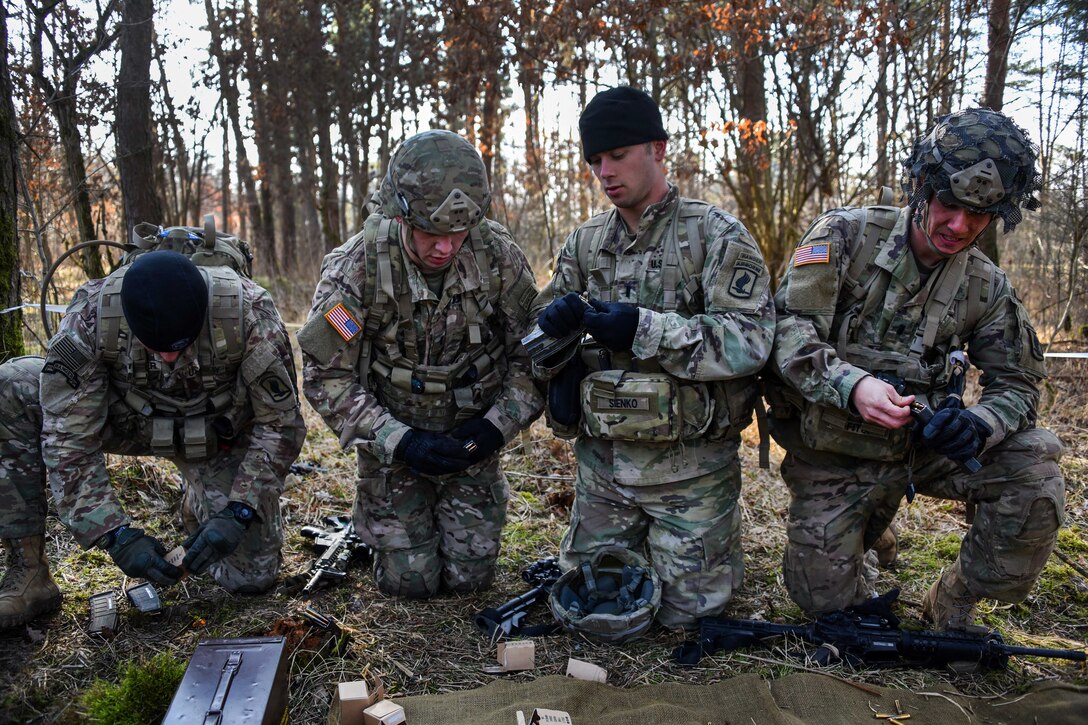 Soldiers load ammunition into weapon magazines.