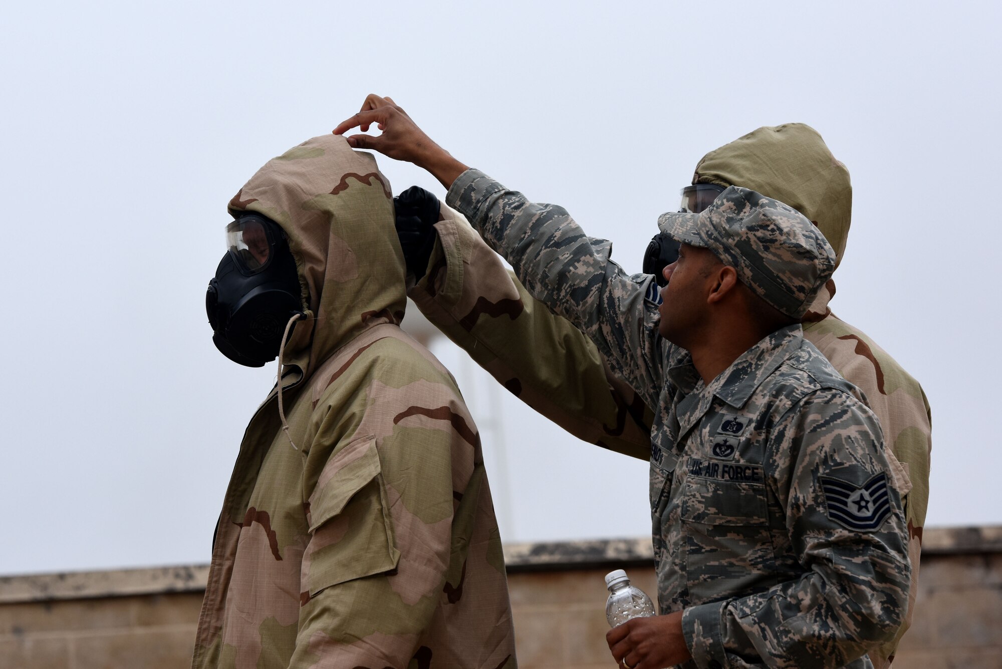 U.S. Air Force Tech. Sgt. Sheraz Cedeno, 17th Civil Engineer Squadron Chemical Biological Radiological and Nuclear instructor, demonstrates how to properly remove Mission Oriented Protective Posture gear during the final training exercise for Warrior Ancillary Specialized Training Program at the mock Forward Operating Base on Goodfellow Air Force Base, Texas, Feb. 28, 2018. The students had to perform various CBRN techniques throughout the exercise. (U.S. Air Force photo by Airman 1st Class Seraiah Hines/Released)