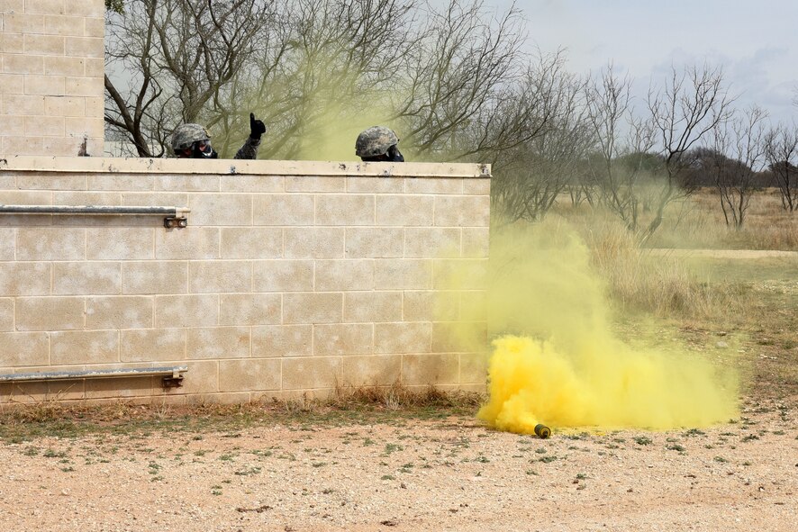 Students in the Warrior Ancillary Specialized Training Program check in with their wingmen through a smoke grenade during their final training exercise at the mock Forward Operating Base on Goodfellow Air Force Base, Texas, Feb. 28, 2018. During the final training exercise smoke grenades were used along with blank ammunition and simulated ground bursts. (U.S. Air Force photo by Airman 1st Class Hines/Released)