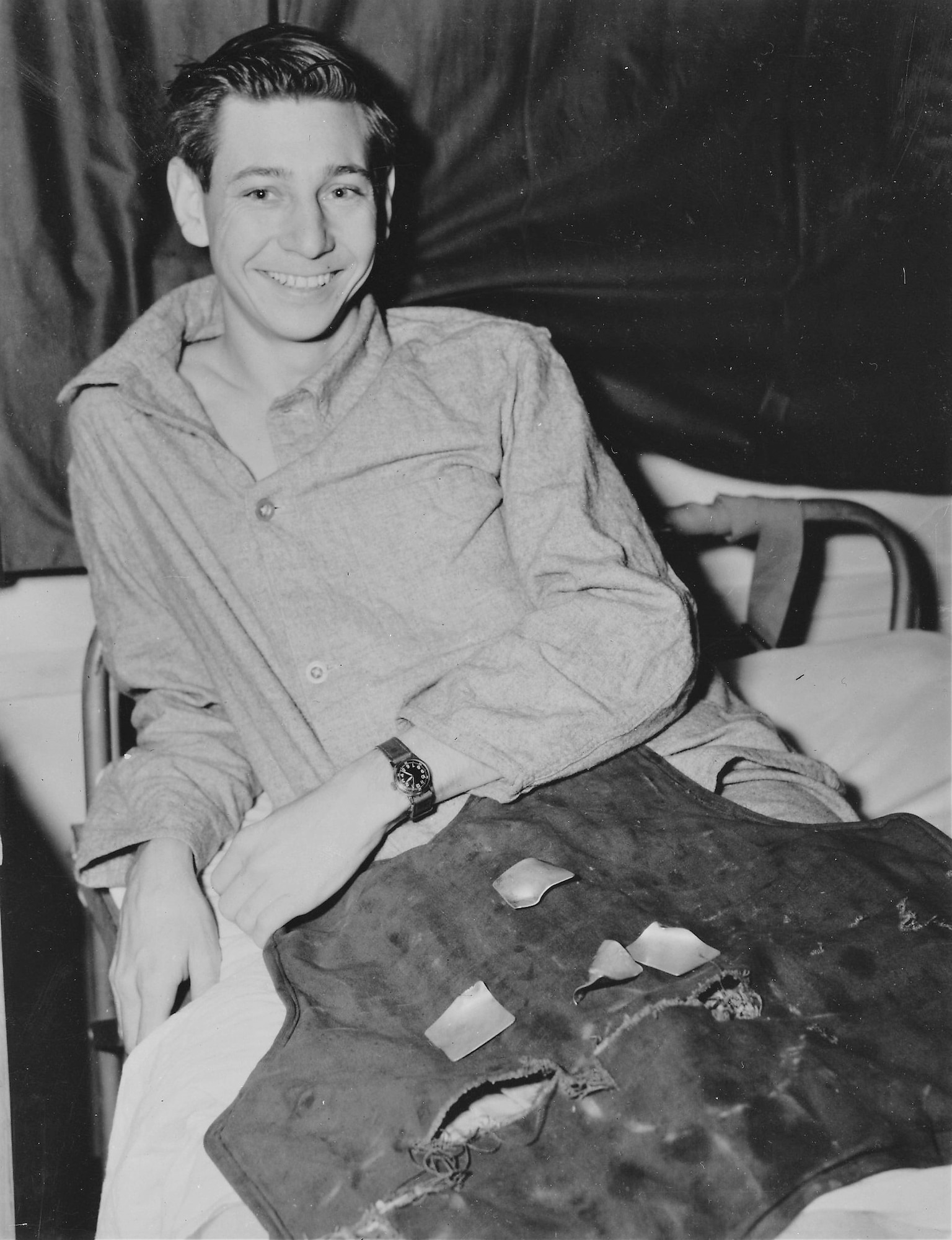 B-17 Flying Fortress radio operator Sgt. James Bothwell, smiles as he displays the back of the flak jacket that saved his life over Germany. He sustained only minor injuries. (U.S. Air Force photo)