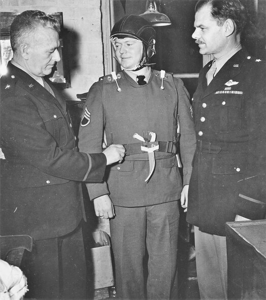 Brig. Gen. Malcolm C. Grow (left), designer of protective equipment for combat fliers, and Brig. Gen. Leon Johnson (right) look over a modified vest and new helmet worn by Staff Sgt. Ambrous T. Hansen (center), a gunner on a B-24 Liberator. (U.S. Air Force photo)