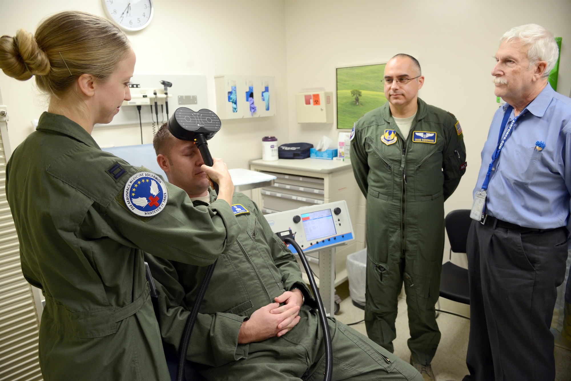 Dr. Stacy Zimmerman, an associate investigator, demonstrates using the Transcranial Magnetic Stimulation (TMS) on Capt. Josh Pearcy, a physician assistant, while Dr. Shane Biedermann and Dr. Harold Ginzburg observe. Biedermann, as the primary investigator, and his team, are looking for combat veteran volunteers with Post Traumatic Stress Disorder to participate in this noninvasive study using electroencephalography.