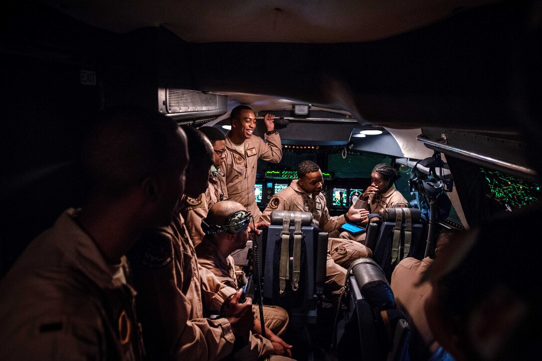 Airmen have a pre-flight meeting inside the cockpit of a C-5M Super Galaxy aircraft.