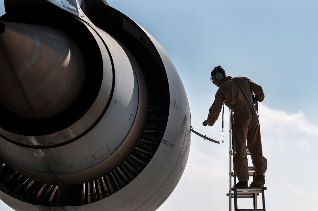 Senior Airman Mikkah Marcellus adds oil to one of the engines on a C-5M Super Galaxy aircraft.