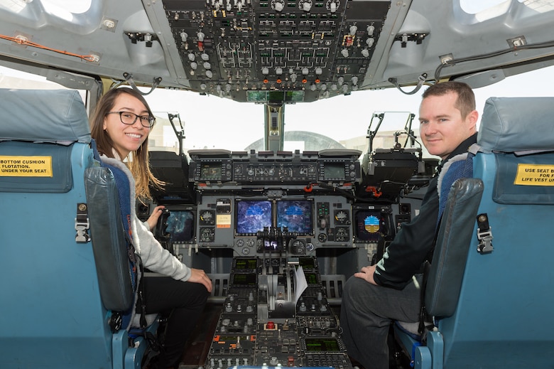 Karen Sanchez, Human Systems Integration engineer, and Matt Osburn, 418th Flight Test Squadron C-17 lead Engineer, sit in the cockpit of a C-17 Globemaster III with new Replacement Head-Up Displays installed for testing. (U.S. Air Force photo by Kyle Larson)